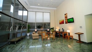 Un vestíbulo amplio con zona de estar, una recepción y un ventanal con vistas al exterior.