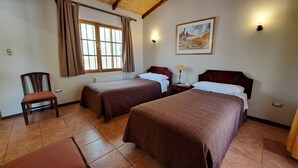 A hotel room with two beds, a chair, a painting on the wall, and a window with curtains. - Diego de Almagro San Pedro de Atacama (San Pedro de Atacama)