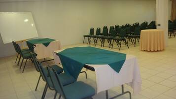 Una sala de conferencias con mesas, sillas y una pizarra.