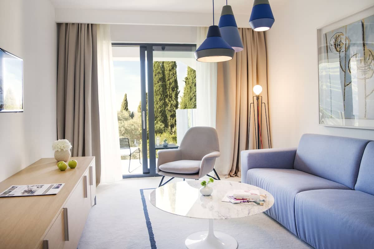 Una sala de estar moderna con un sofá, una mesa redonda, una silla y una lámpara de pie.