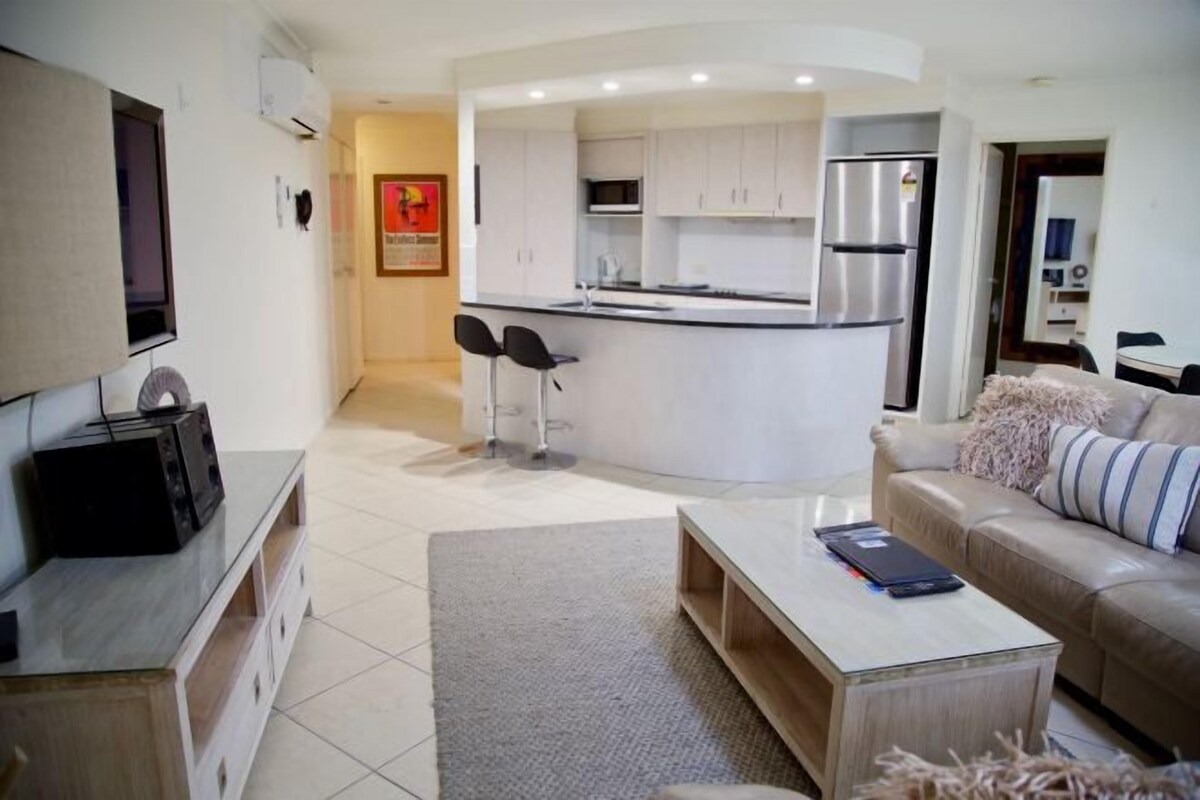 Un apartamento moderno con cocina, sala de estar y un pequeño comedor.