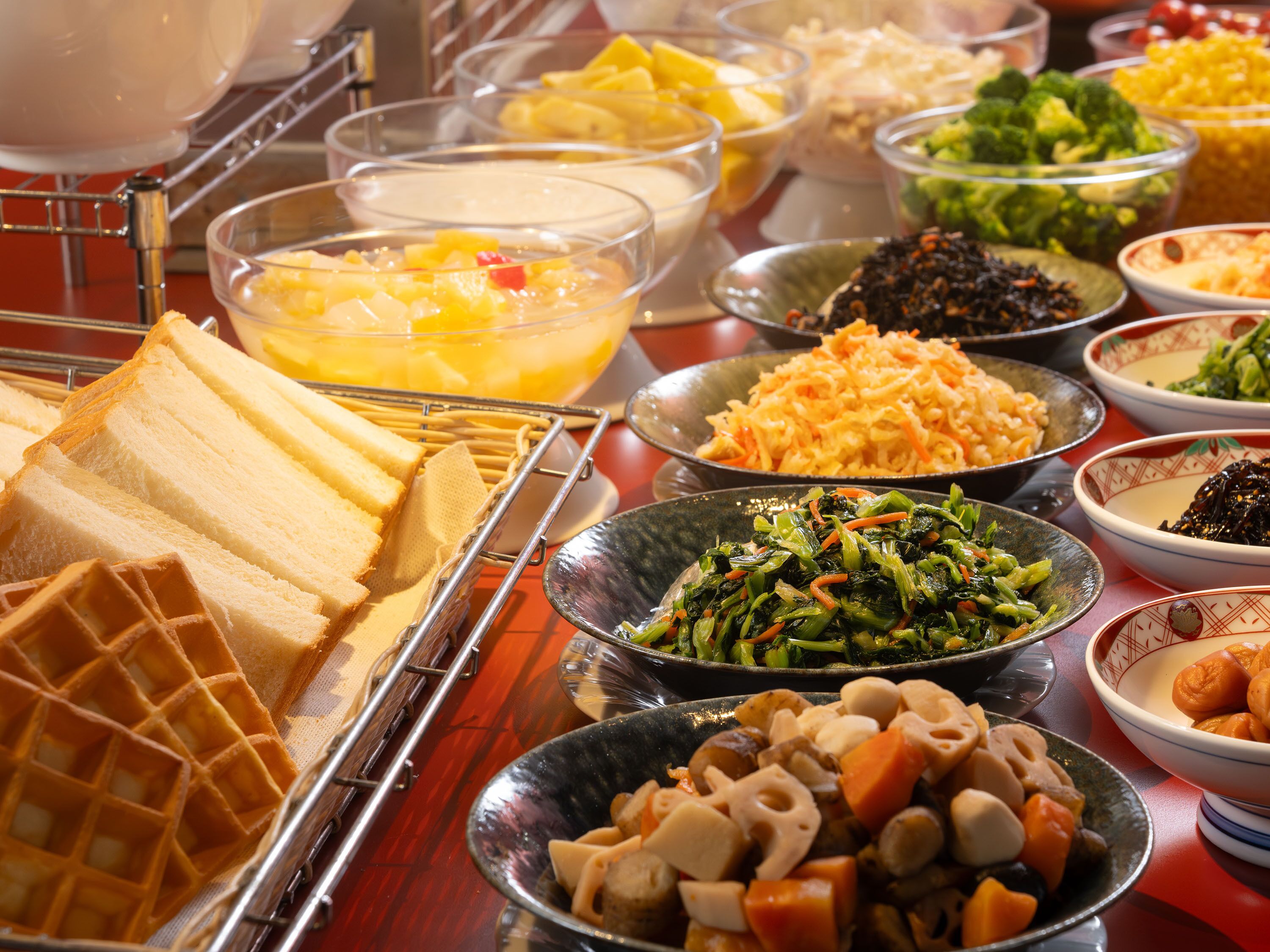 Een buffet met diverse gerechten, waaronder wafels, salades en groentemengsel.