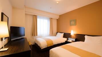 A hotel room with two beds, a TV, a desk with a lamp, and a bedside table with a phone.