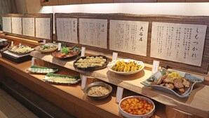Un bufé con diversos platos y menús en japonés.
