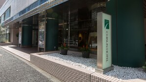 The exterior of the Chisun Hotel with a tiled entrance, potted plants, and a clear glass facade. - Chisun Hotel Hamamatsucho (Tokyo)