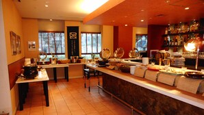 A restaurant with a long counter, multiple tables, and a variety of dishes displayed. - Chisun Hotel Hamamatsucho (Tokyo)