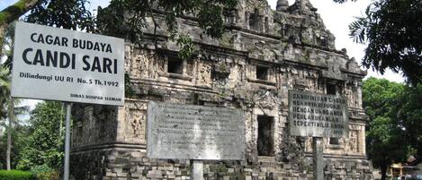 Una estructura de piedra histórica con inscripciones y un cartel.