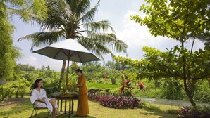 A garden with a palm tree, a table, and two people.