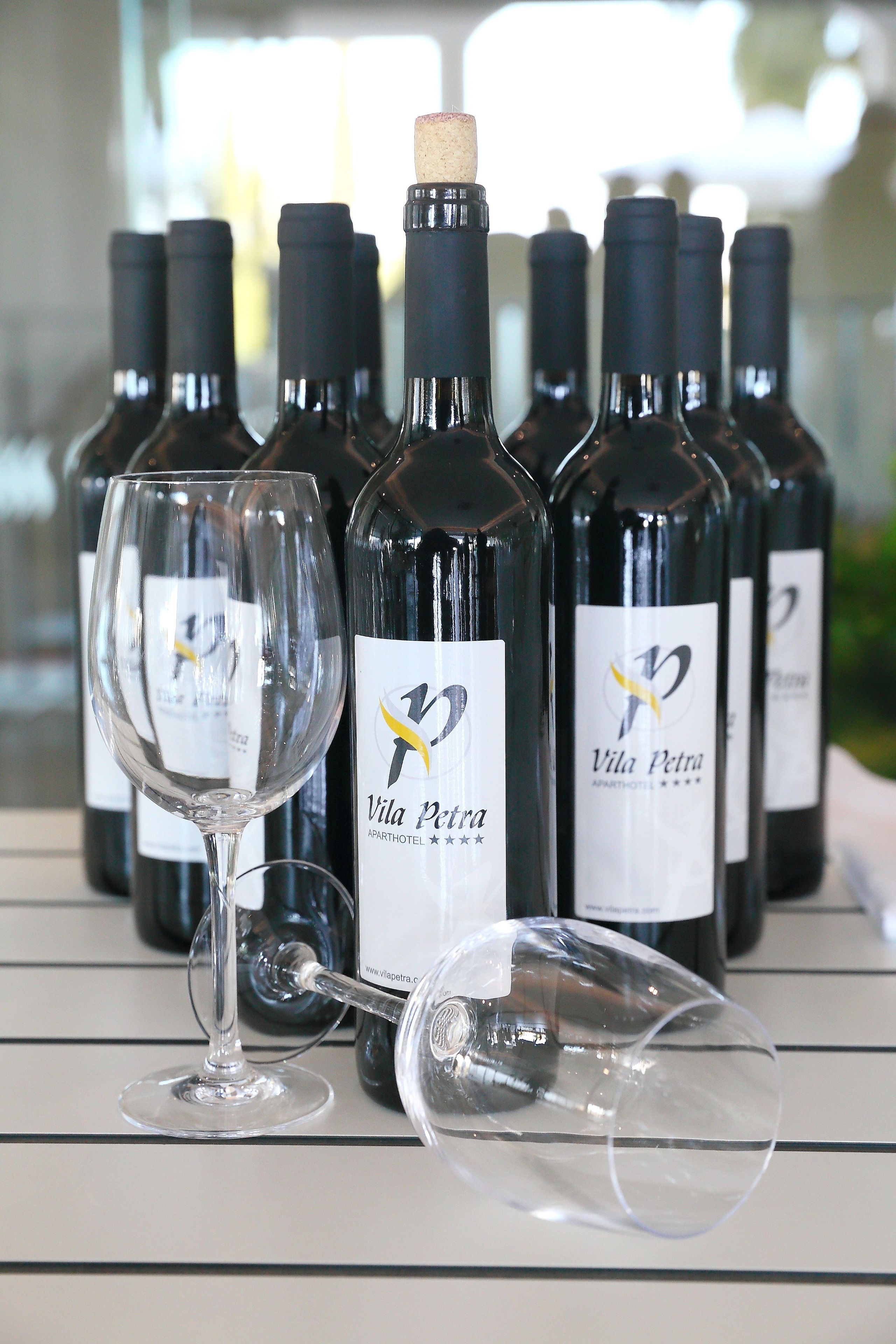 Varias botellas de vino con etiquetas y una copa de vino al frente.