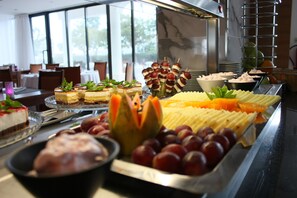 A buffet with various food items including desserts, fruits, and vegetables.