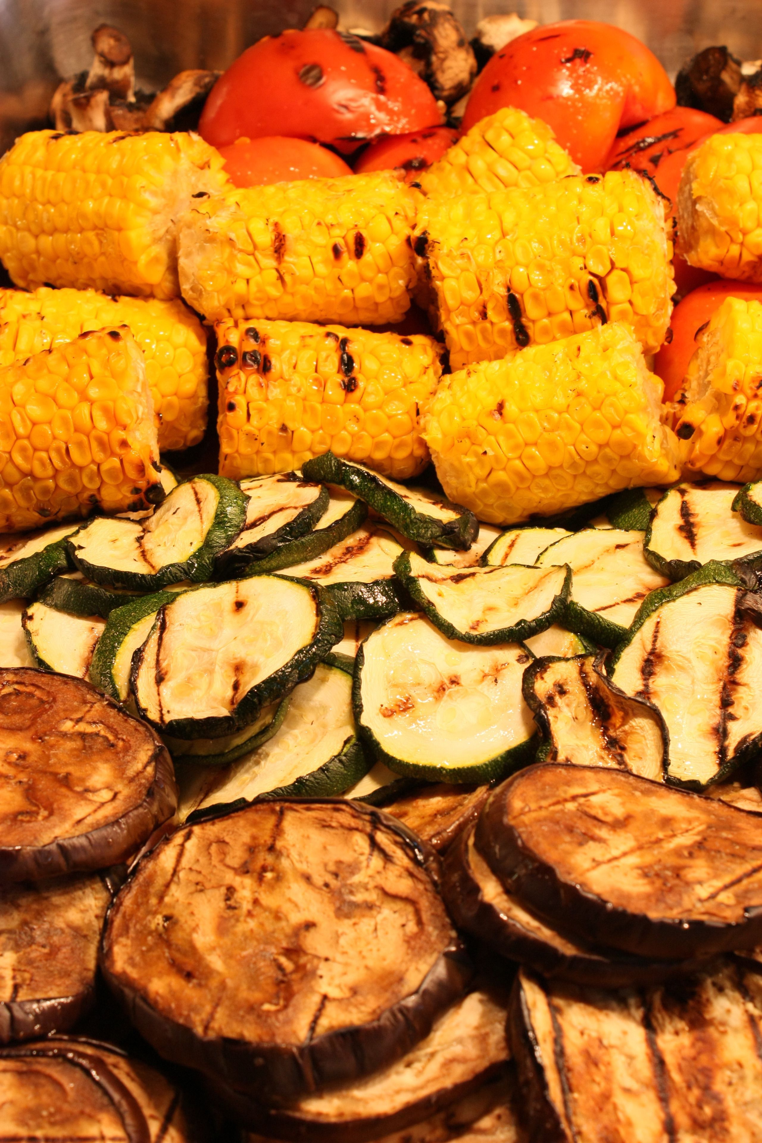 Grilled vegetables including corn, zucchini, and eggplant.