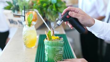 A person using a lighter to light a candle on a green mat.