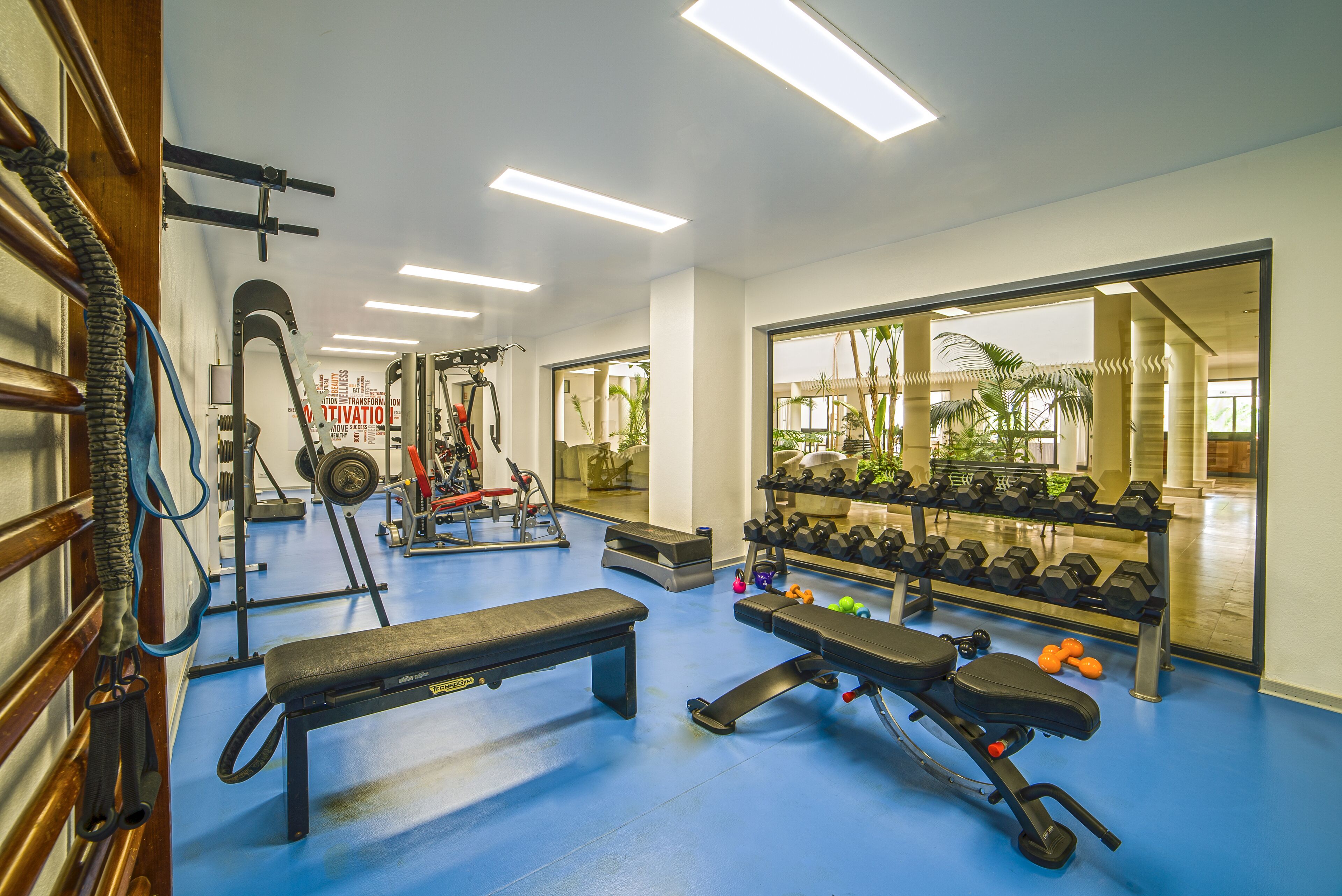 A gym with benches, dumbbells, and exercise equipment.