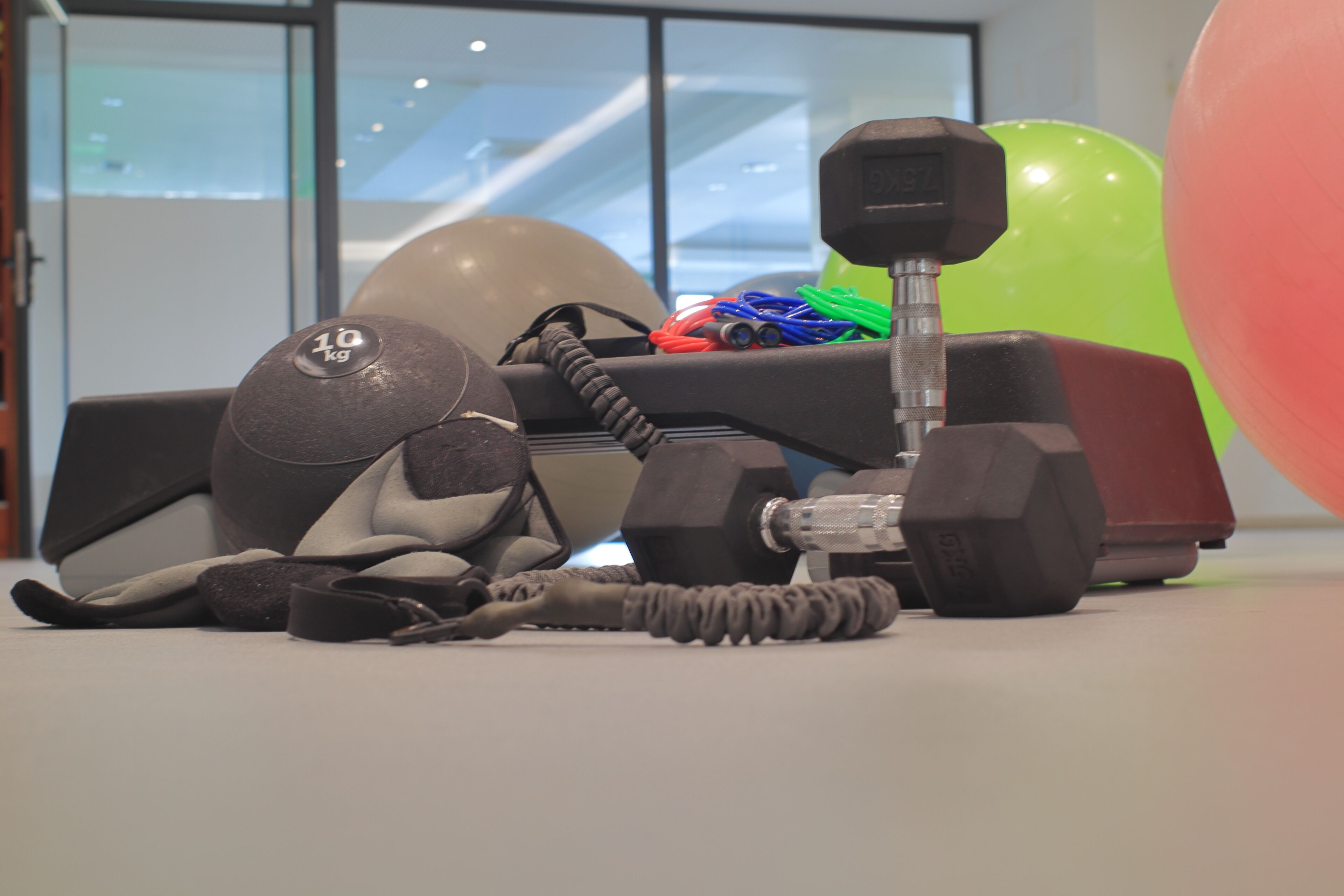 Gimnàs amb equip d'exercici, incloent pesos, un matoi de ioga i una kettlebell.