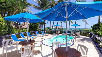Relax by the ocean-view pool surrounded by lounge chairs and umbrellas.