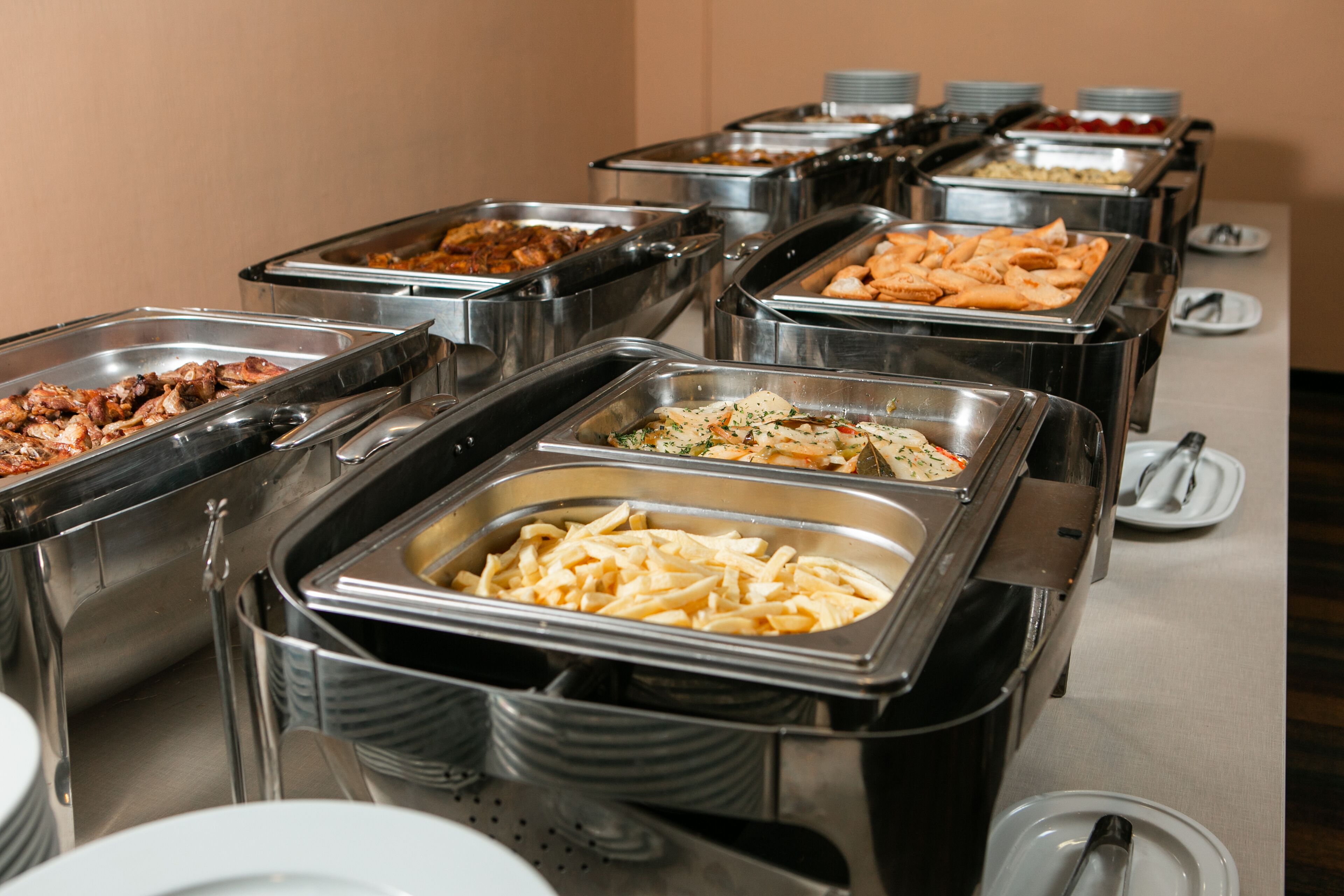 Een buffet met diverse gerechten in metalen bakken.