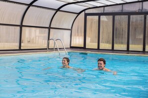 An indoor swimming pool with clear water, a ladder, and a glass enclosure. -  RVHotels Tuca (Vielha e Mijaran)