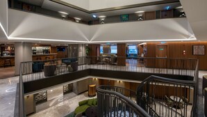A multi-level hotel lobby with a central staircase, seating areas, and a bar. - DoubleTree by Hilton Hotel Istanbul - Sirkeci (Istanbul)