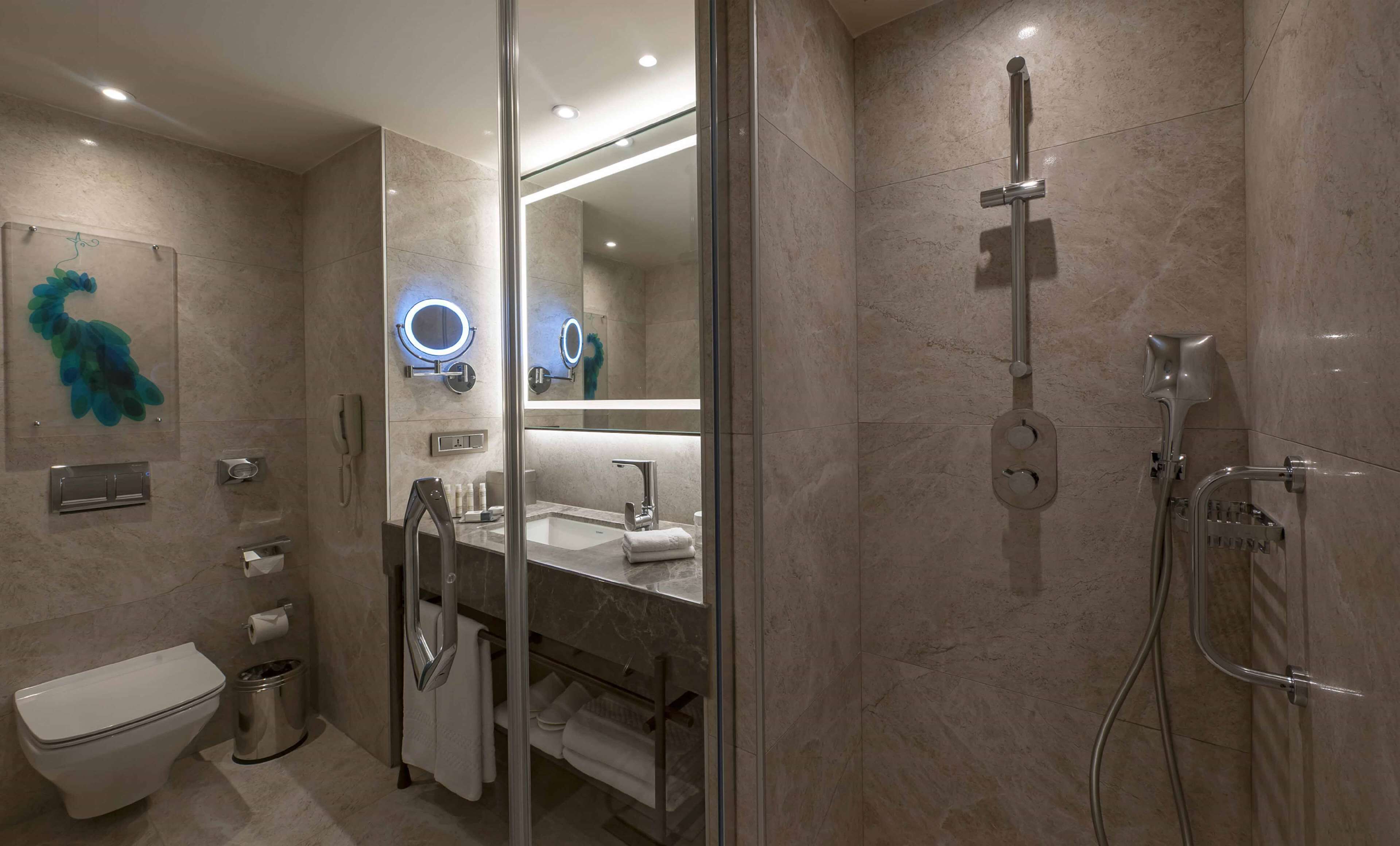 A modern bathroom with a glass-enclosed shower, a vanity with a mirror, and a toilet.