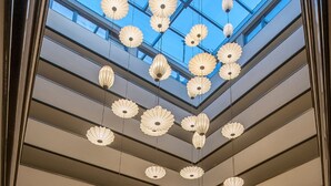 A modern interior with a skylight ceiling, multiple levels, and hanging paper lanterns. - DoubleTree by Hilton Hotel Istanbul - Sirkeci (Istanbul)