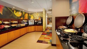 A buffet area with various food stations, a coffee machine, and a waffle maker. - Fairfield Inn & Suites Germantown Gaithersburg (Germantown)