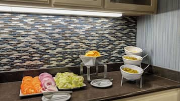 Un comptoir de cuisine avec divers aliments et un revêtement mural décoratif.