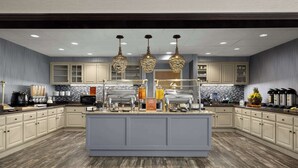 A modern kitchen with a central island, built-in cabinets, and pendant lighting. - Homewood Suites by Hilton Bakersfield (Bakersfield)