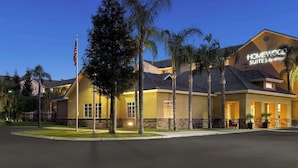 A hotel with a yellow facade, stone accents, and a sign reading "HOMEWOOD SUITES BY HOMEWOOD". - Homewood Suites by Hilton Bakersfield (Bakersfield)
