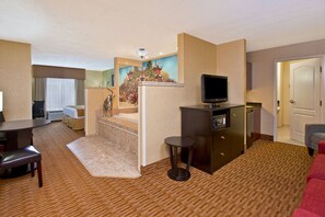 A hotel room with a dining area, a TV, a small table, and a sofa. - Holiday Inn Express & Suites Sharon-Hermitage by IHG (West Middlesex)