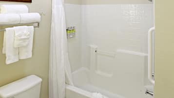 Une salle de bain avec une baignoire, des toilettes et un rideau de douche.