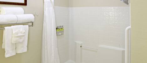 A bathroom with a bathtub, toilet, and a shower curtain.