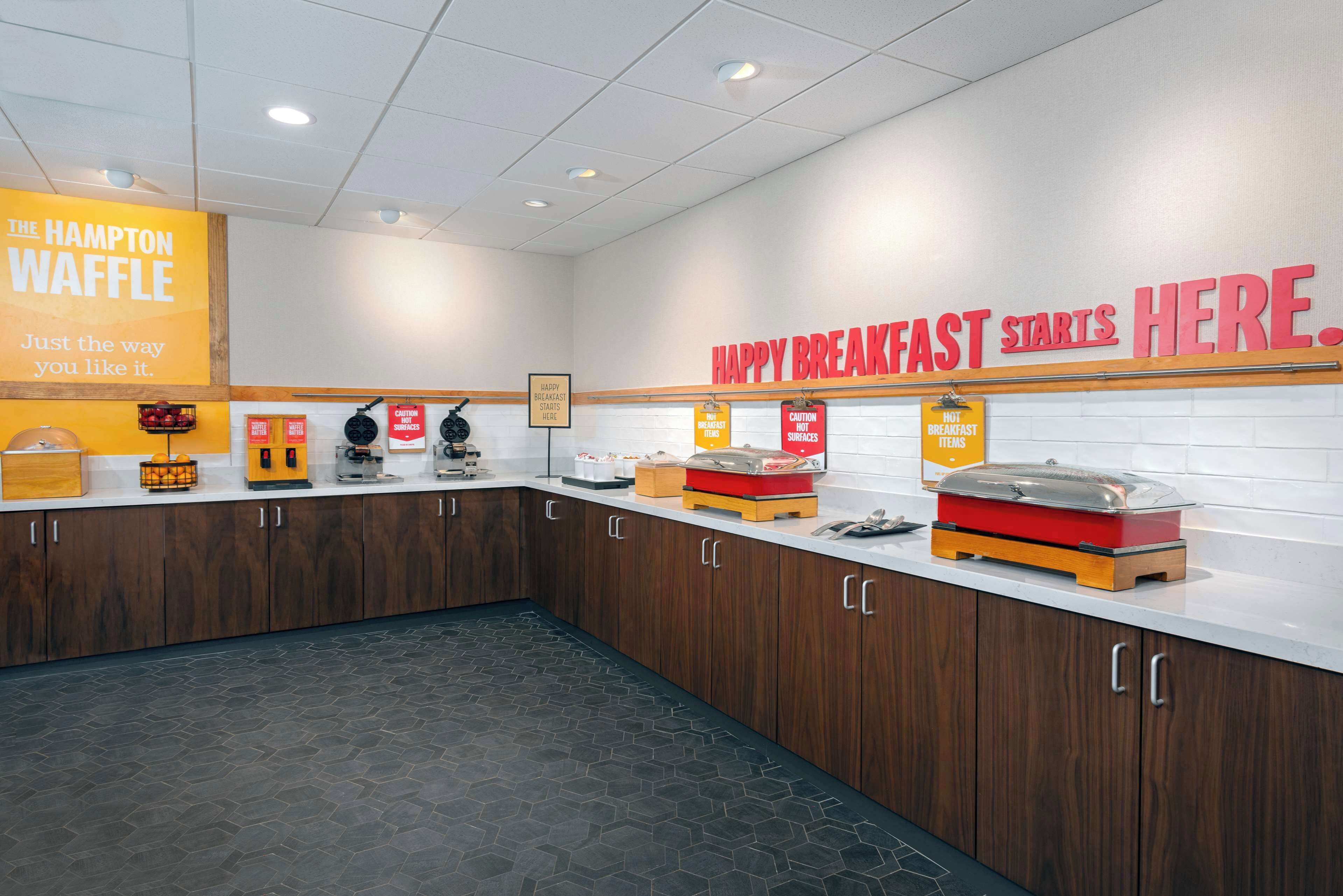 A breakfast area with a sign reading "HAPPY BREAKFAST STARTS HERE."