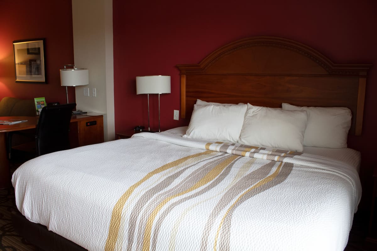 Ein Hotelzimmer mit einem großen Bett, einem Schreibtisch und zwei Lampen.