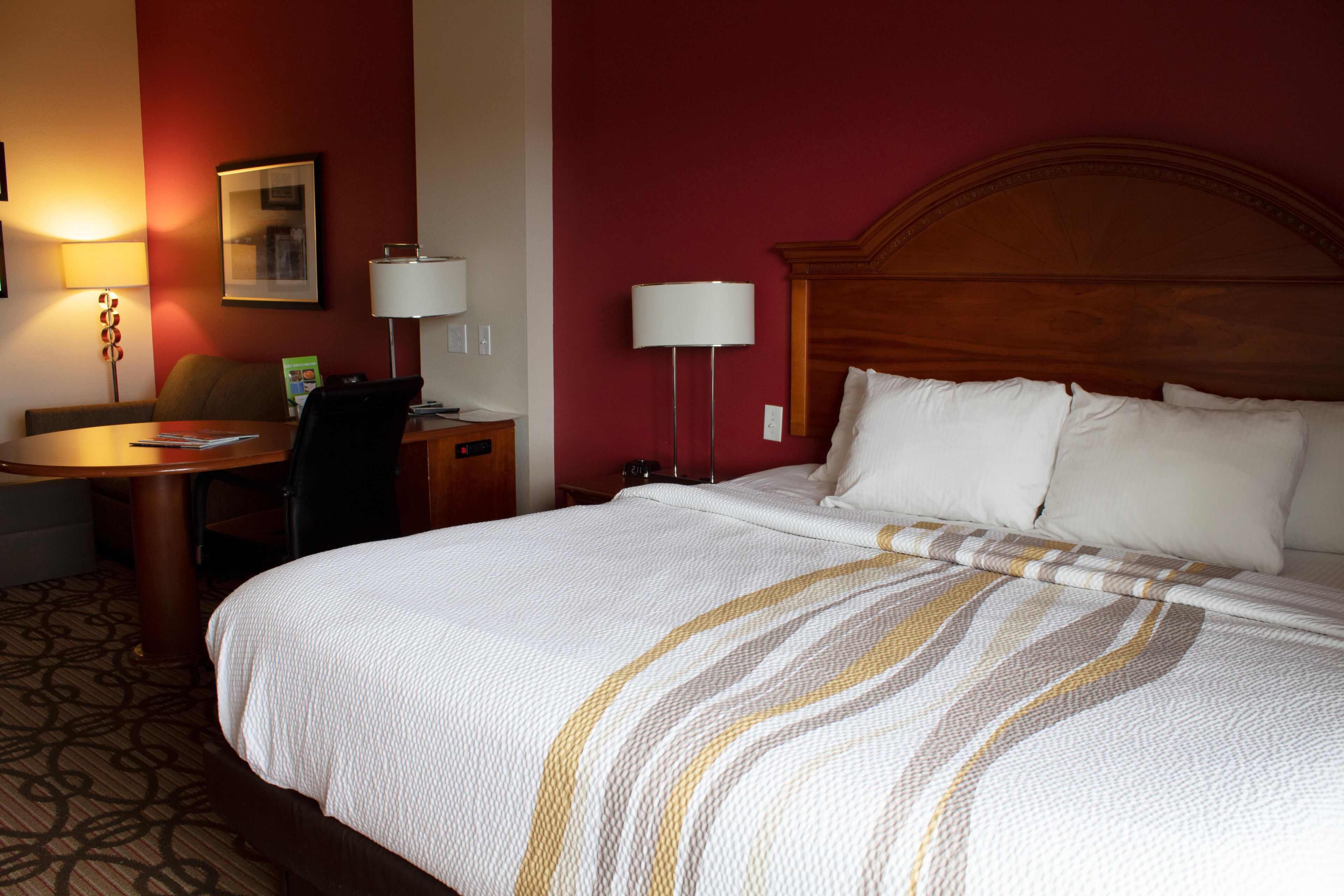 Una habitación de hotel con una cama grande, un escritorio y una silla.