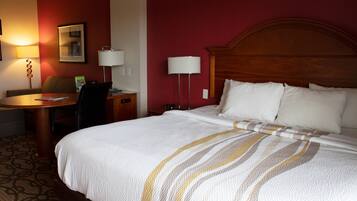 Una habitación de hotel con una cama grande, un escritorio y una silla.