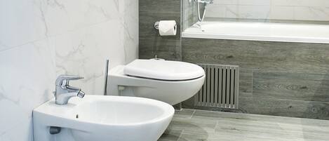 Un baño moderno con bidé, inodoro y bañera.