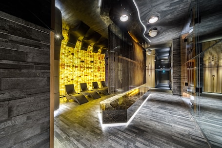 A modern lobby with a reception desk, seating area, and a patterned wall.