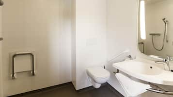 Une salle de bain moderne équipée de toilettes, d’une douche et d’un lavabo.