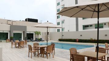 Piscine extérieure, parasols de plage, chaises longues