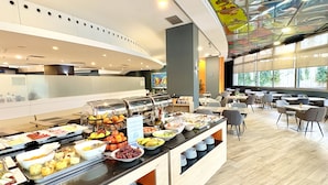 Een buffetgedeelte met diverse gerechten en een zithoek met tafels en stoelen.