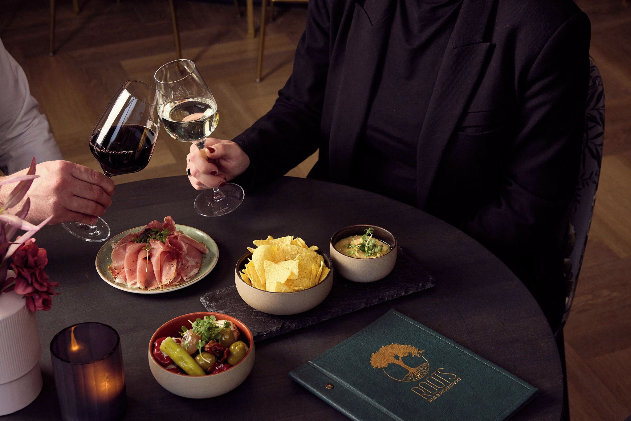 Una mesa con comida, bebidas y una carta.