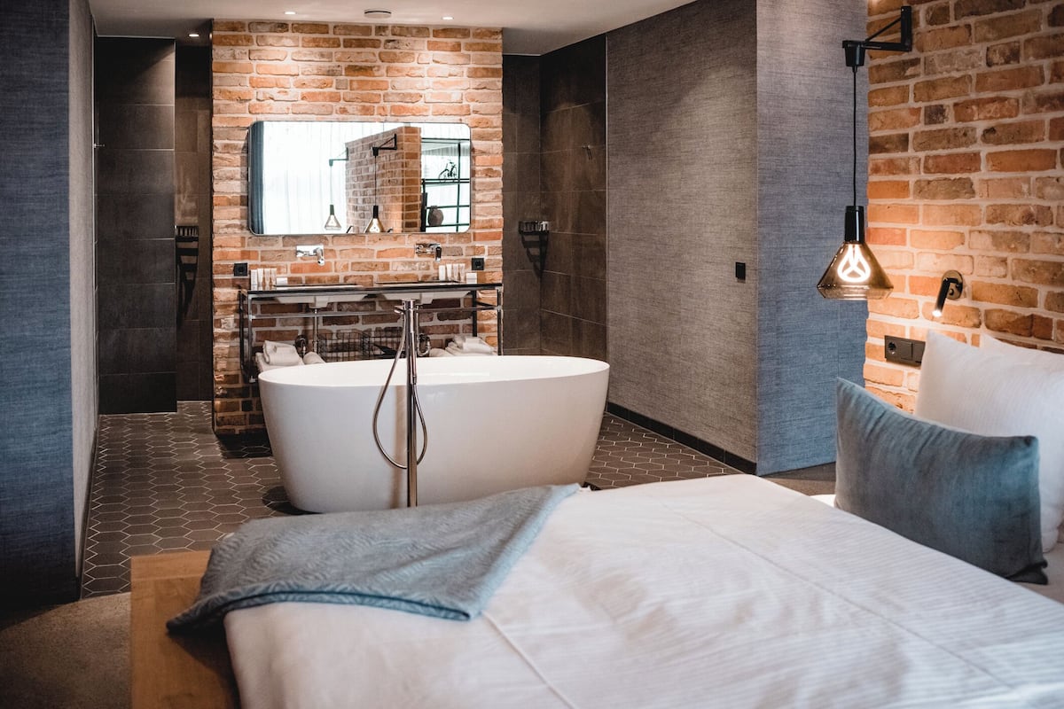 A modern bathroom with a freestanding bathtub, a large mirror, and a shower area.