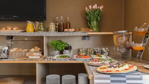 A buffet setup with various food items, including pastries, salads, and beverages. - Hotel Perla (Kraków)