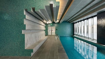 Relax by the pool surrounded by a mosaic tile pattern and linear lighting.