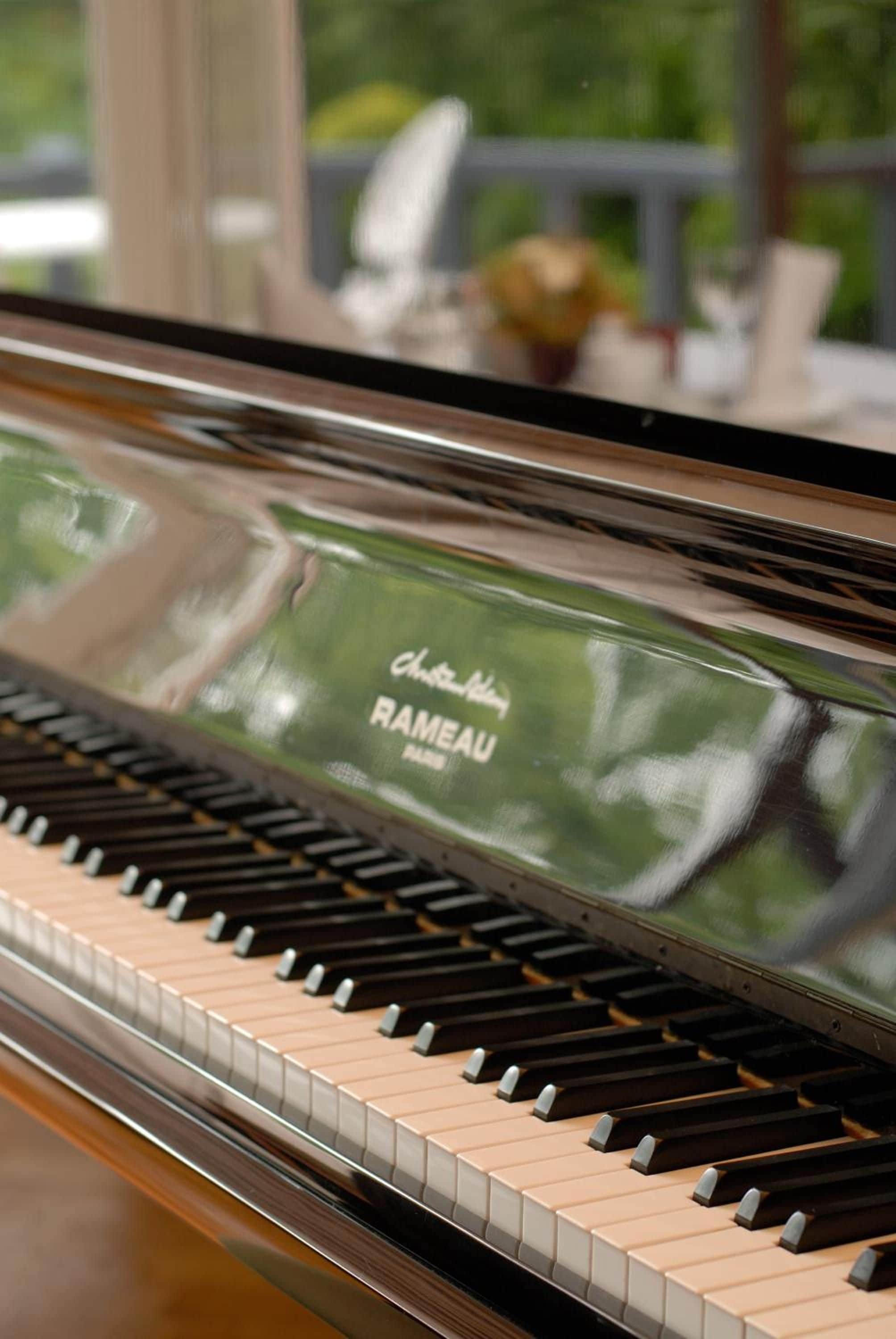 Un piano con una superficie reflectante, posiblemente un piano de cola, con el nombre de una marca a la vista.