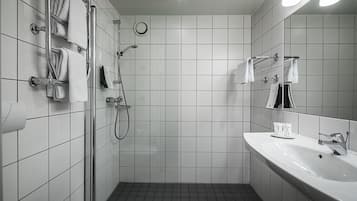A modern bathroom with a shower, a sink, and a mirror.