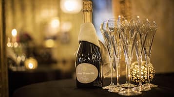 Een fles Jean Vesselle Brut Prestige champagne en verschillende champagneglazen op een tafel.