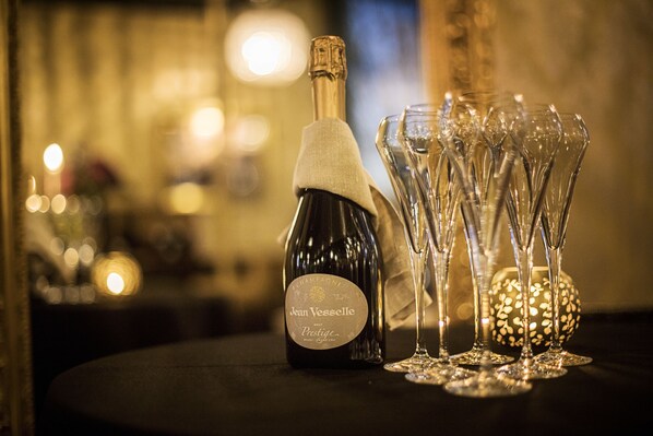 Une bouteille de champagne Jean Vesselle Brut Prestige et plusieurs flûtes à champagne sur une table.
