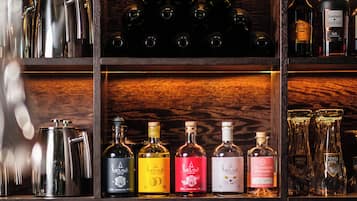 Uma área de bar com prateleiras exibindo diversas garrafas e copos.