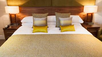 Una habitación de hotel con una cama grande, dos lámparas de noche y un cabecero de madera.